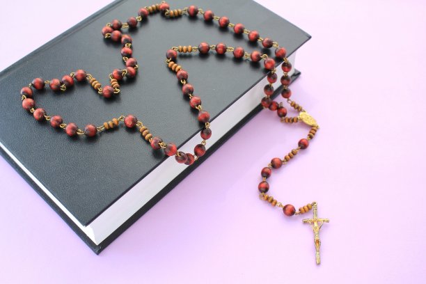 念珠木珠和十字架基督十字架上神圣的圣经书紫色的背景图片下载