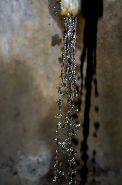 水像水钻一样从水龙头里溅出来。水滴和从水龙头滴落的水。图片下载