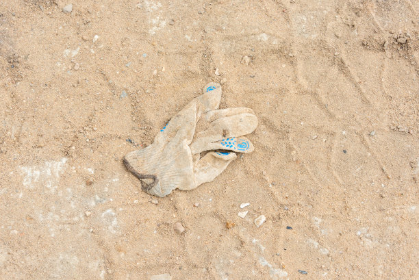 扔出去或忘记的施工手套和拖拉机轮胎印。图片下载