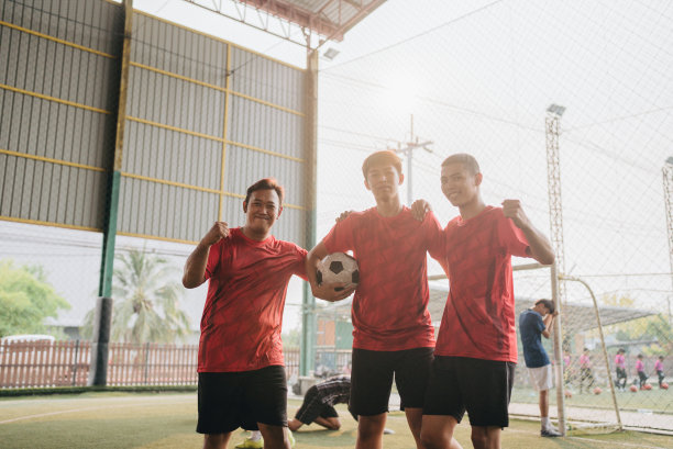 亚洲男子足球运动员正在和朋友打球。图片下载