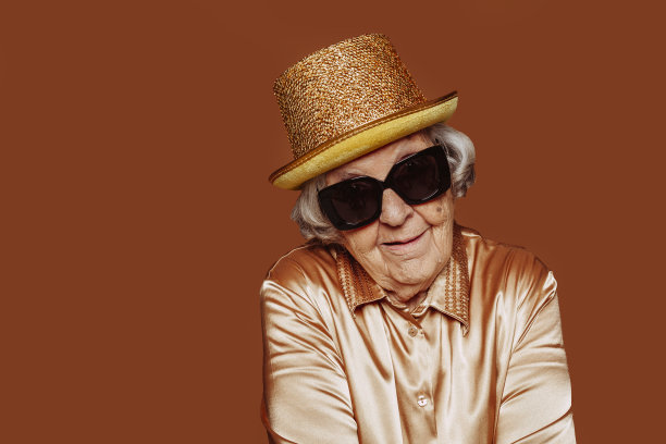 时髦的退休祖母摆着滑稽的脸在工作室图片下载