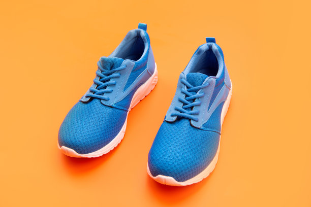 橙色背景的鞋子。鞋店。购物的概念。鞋进行训练。图片下载