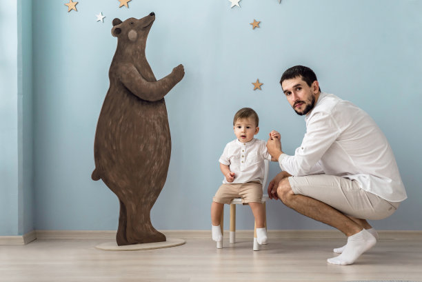 肖像快乐的爸爸和小儿子，看着相机，帅气的爸爸和可爱的小男孩一起摆姿势拍全家福图片下载