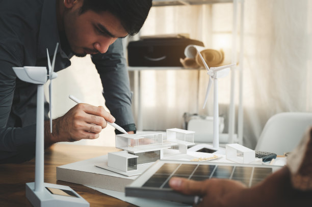 专门设计和计算为现代家庭提供纯能源的工程师。指向屋顶区域安装太阳能电池板。未来利用太阳能节约电力。图片下载