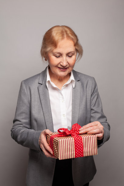 年长商务女性打开红色礼盒赠送肖像图片下载