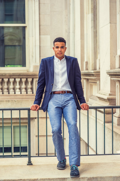 一个年轻人坐在纽约市办公楼外图片下载