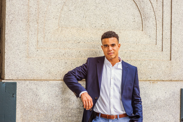 年轻人站在纽约街头的墙边图片下载