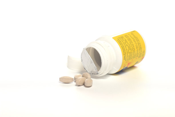 从白色塑料瓶里洒出维生素C图片下载