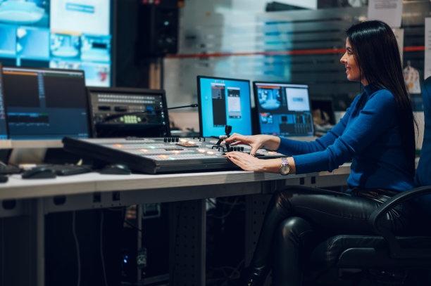 在电视台控制室使用设备的中年妇女图片下载