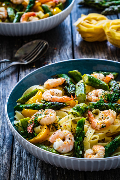 木桌上放着炸大虾和芦笋的意大利扁面条图片下载