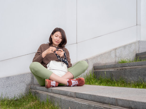女人在户外编织。都市公园中女性的宁静休闲。抗应激的爱好。图片下载