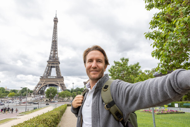 一名年轻人在巴黎埃菲尔铁塔自拍图片下载
