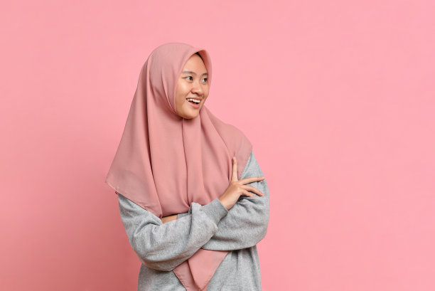 亚洲穆斯林妇女的肖像戴着头巾微笑，看着一边的copyspace图片下载
