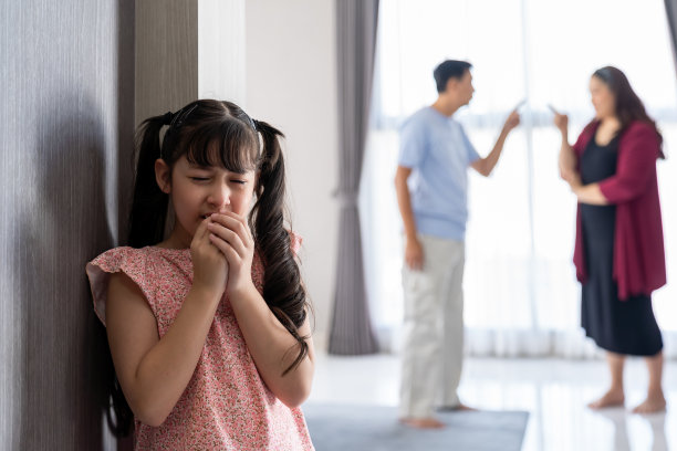 伤心的孩子女孩哭着，泪水从父亲和母亲争吵，然后感到沮丧和孤独。小女孩因为父母吵架而哭泣。家庭消极，吵架观念强。图片下载
