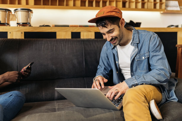 坐在沙发上用笔记本电脑的男人图片下载