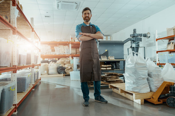 微笑的企业主站在咖啡烘焙机的背景图片下载