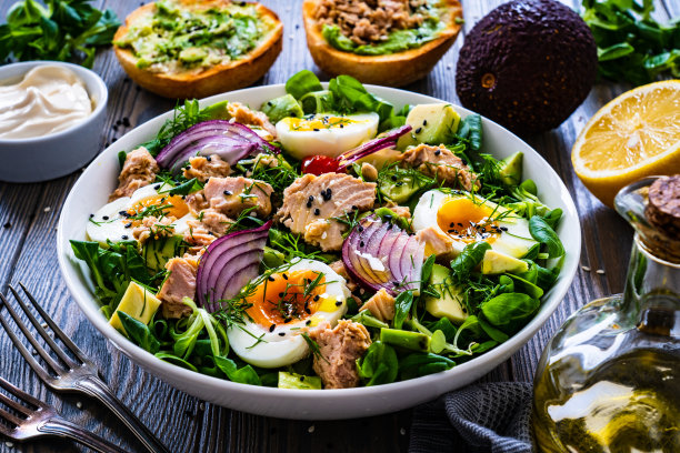金枪鱼，煮鸡蛋，牛油果和蔬菜沙拉的木制背景图片下载