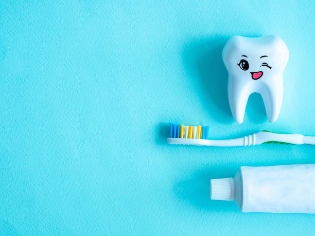 牙科口腔卫生概念。一根带塑料牙签的牙线，一颗带微笑的牙齿，一根牙膏和一把刷子，一个放文字的地方图片下载