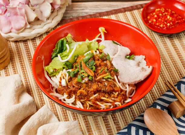 招牌干面放在碗里，用勺子和筷子隔在凉席上，侧观木桌上的台湾菜图片下载