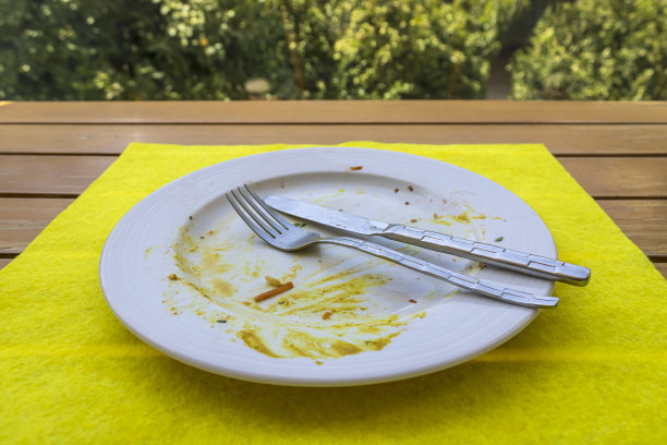 花园桌上放着剩菜的脏盘子图片下载
