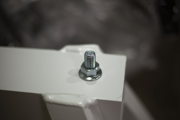 螺母拧在螺栓上。固定的部分。白色的建筑。成品钢产品。描绘对象。图片下载