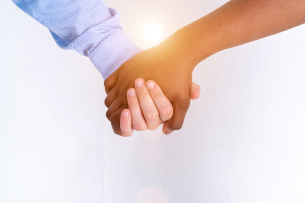 一名白人男孩和一名黑人少女的手臂相拥的偷拍照片。握手的儿童。坦诚的夫妇。没有脸。少年时期的初恋。阳光灿烂。图片下载