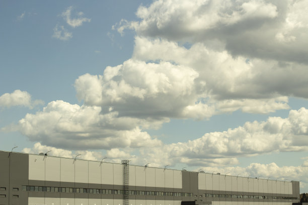 仓库和天空。灰色建筑。乌云笼罩着仓库。图片下载