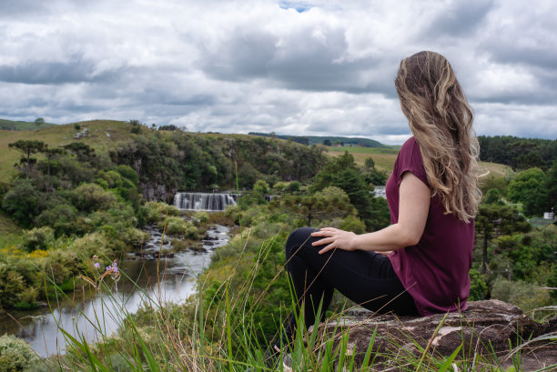 冒险的女人看着瀑布的景色图片下载