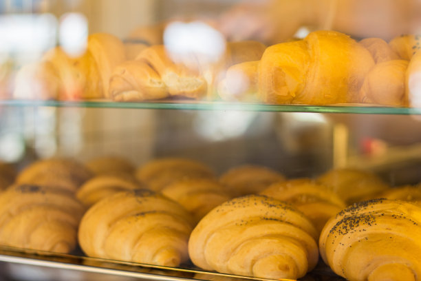 新鲜出炉的牛角面包。展柜里的新鲜羊角面包。自制的糕点。市场摊位上的面包店。面包卖。早餐的概念。早上咖啡馆里美味的羊角面包。图片下载