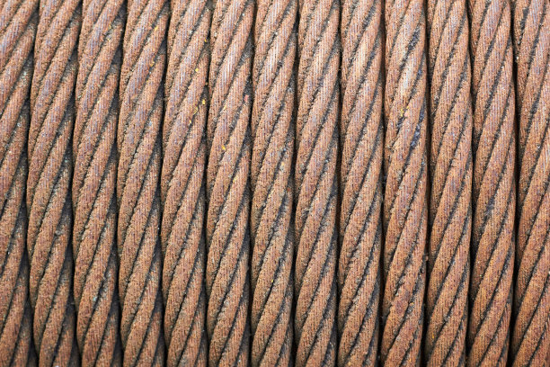 钢索吊具。旧的过时的生锈的钢编织电缆受伤的卷筒工业绞车选择性聚焦宏观特写纹理背景。图片下载