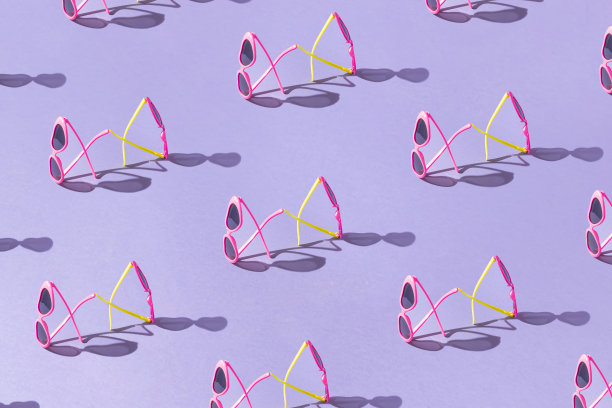 夏天的创意图案制成的彩色心形太阳镜对紫色的背景。最小的度假的概念。时髦的防晒理念。海滩时尚眼镜。阳光下的阴影。图片下载