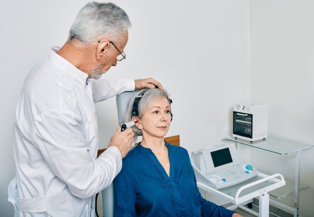 成熟的听力学家在听力门诊用听筒探头为老年女性患者进行程序性听诊或阻抗听诊图片下载
