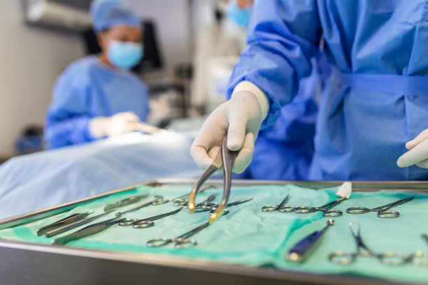 带器械的手术台手术室，手术过程中助手为外科医生捡取器械。手术的进展。专业外科医生。图片下载