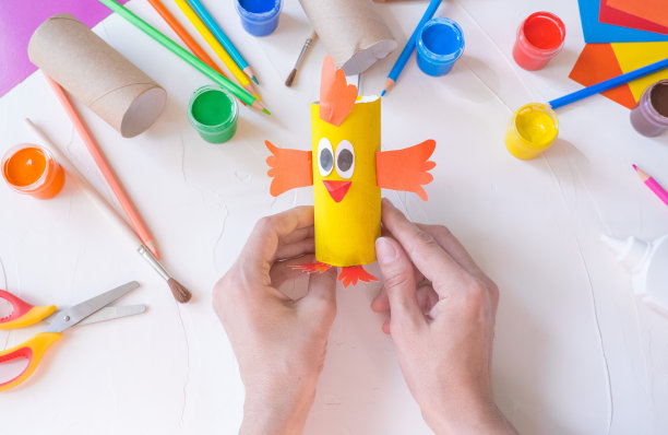 假期轻松DIY手工想法的孩子。卫生纸卷管玩具小鸡宝宝在白色背景与彩色纸..创意复活节装饰环保、重复利用、回收利用、零浪费的手工极小概念图片下载