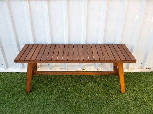 复古风格的木凳放在人造草坪上。图片下载