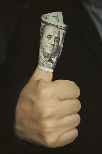 手里拿着钱——商业成功的象征。一百美元钞票图片下载
