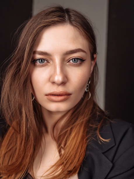 积极的技术年轻女工的肖像与长棕色头发望着相机感到高兴和自豪的工作人员到公司。垂直的。图片下载