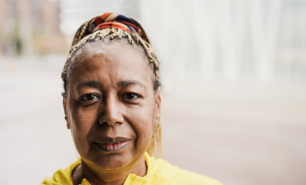 年长非洲妇女看相机户外-聚焦在脸上图片下载