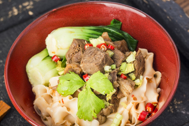 辣红汤汁牛肉面放在木桌上的碗里图片下载