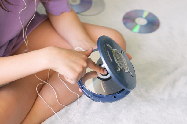 女孩将耳机连接到CD播放器听音乐，青少年娱乐休闲图片下载