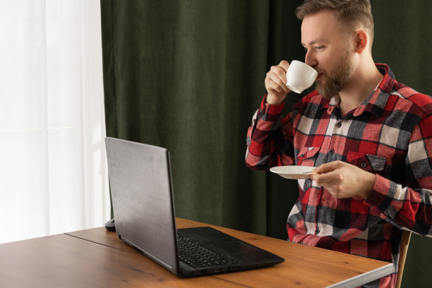 千禧一代的商人在咖啡馆喝早上的咖啡用笔记本电脑工作，远程自由职业者在家庭办公室，商业和自由职业图片下载