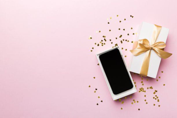 打开礼品盒，金色丝带和智能手机彩色背景，俯视图。空白开箱包装模型，模板为您的设计品牌模型图片下载