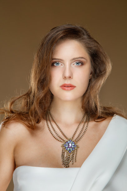 年轻的金发女子的肖像，穿着白色连衣裙的肩膀和项链，看着相机图片下载