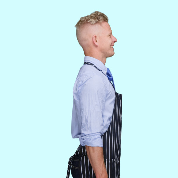 身穿围裙的白人男性屠夫站在蓝色背景前图片下载