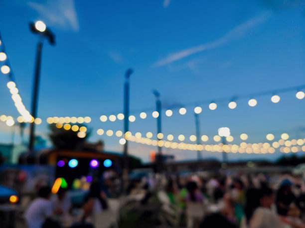 模糊抽象的人们在花园中伴着音乐进餐。图片下载