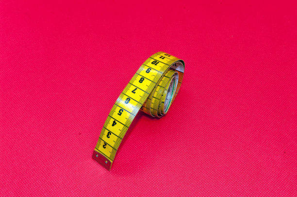 灵活的裁缝卷尺，独立的红色背景图片下载