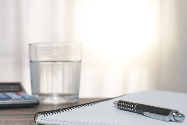 笔记本，钢笔，计算器和一杯水图片下载