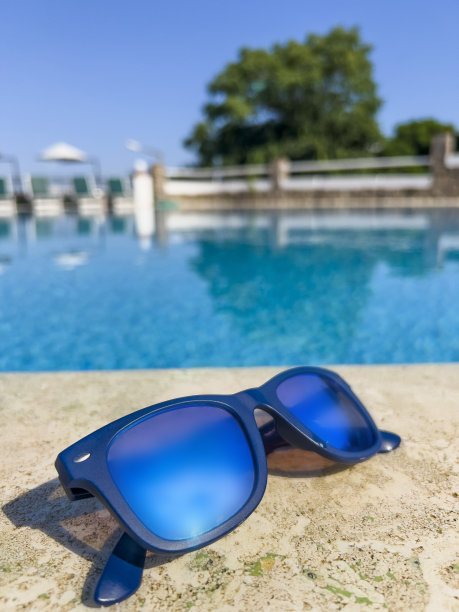 游泳池背景上的蓝色镜子太阳镜图片下载