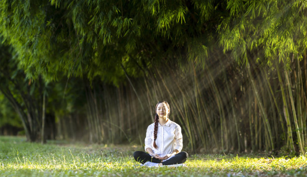 女人在竹林中放松地练习冥想，从内心的平静中获得幸福，为健康的身心和健康的灵魂概念的智慧图片下载