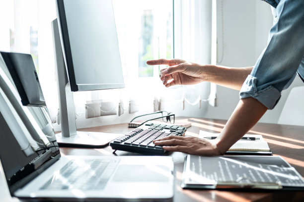 亚洲女性程序员指着电脑屏幕上的代码数据，同时用键盘编写代码数据图片下载